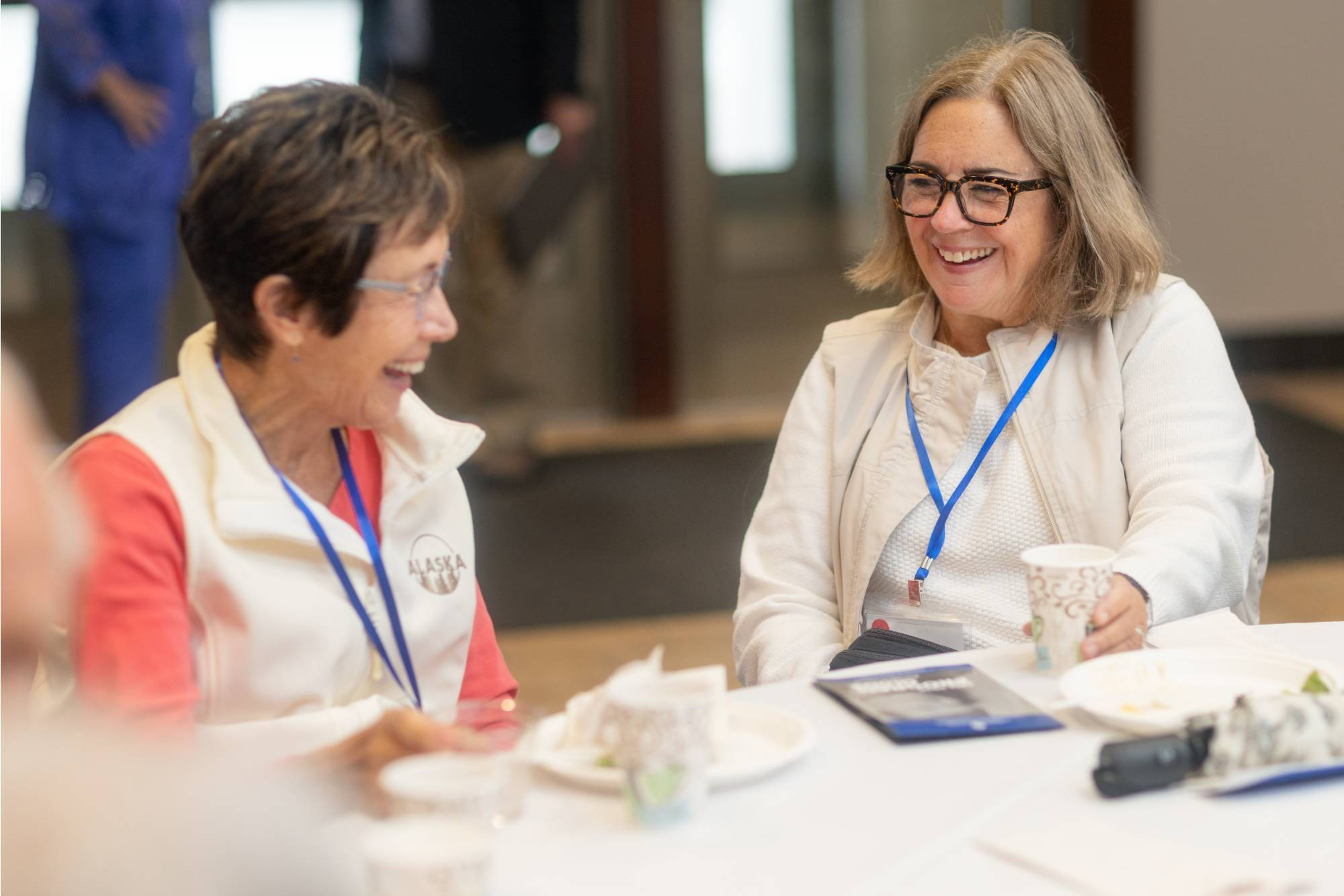 Grand Forum attendees smile and discuss the most recent presentation.